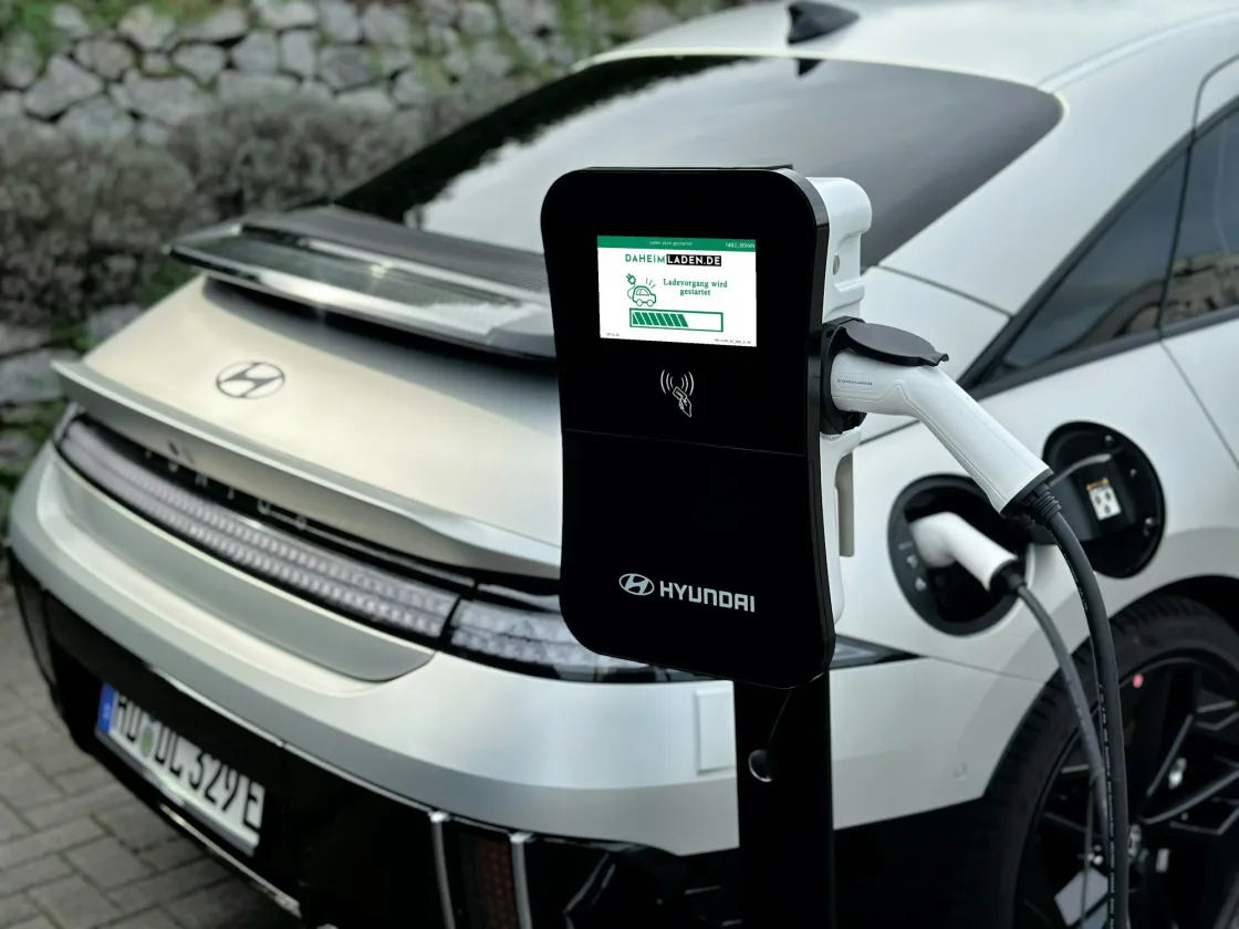 An electric vehicle charging from a wall-mounted charger
