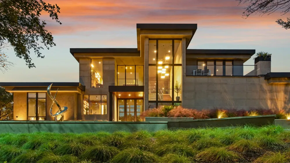 A modern residential property lit at dusk