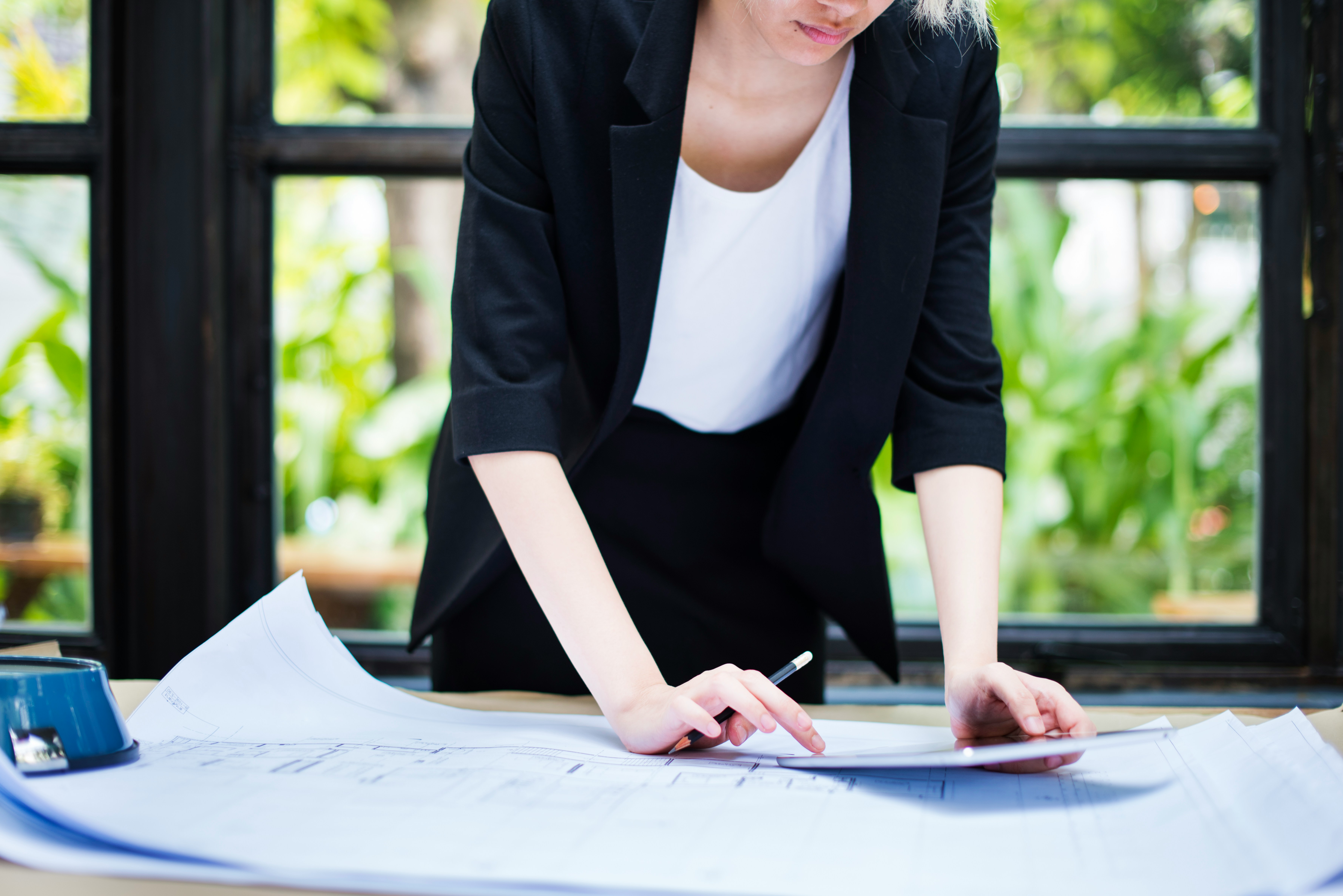 A professional reviewing site plans at a desk